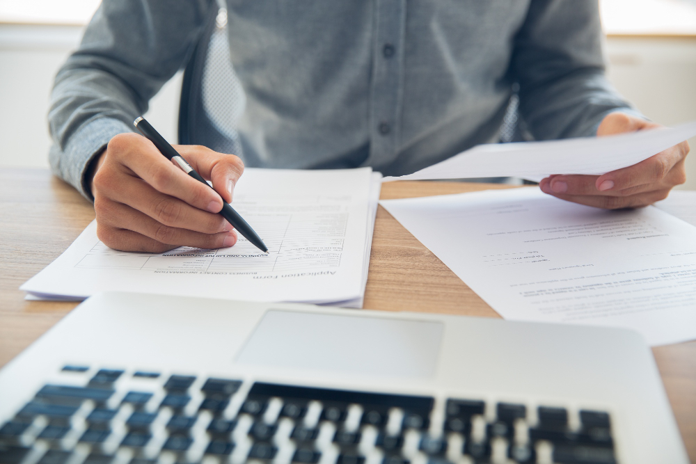 Arizona parent reviewing ESY denial paperwork at home office table in warm afternoon light